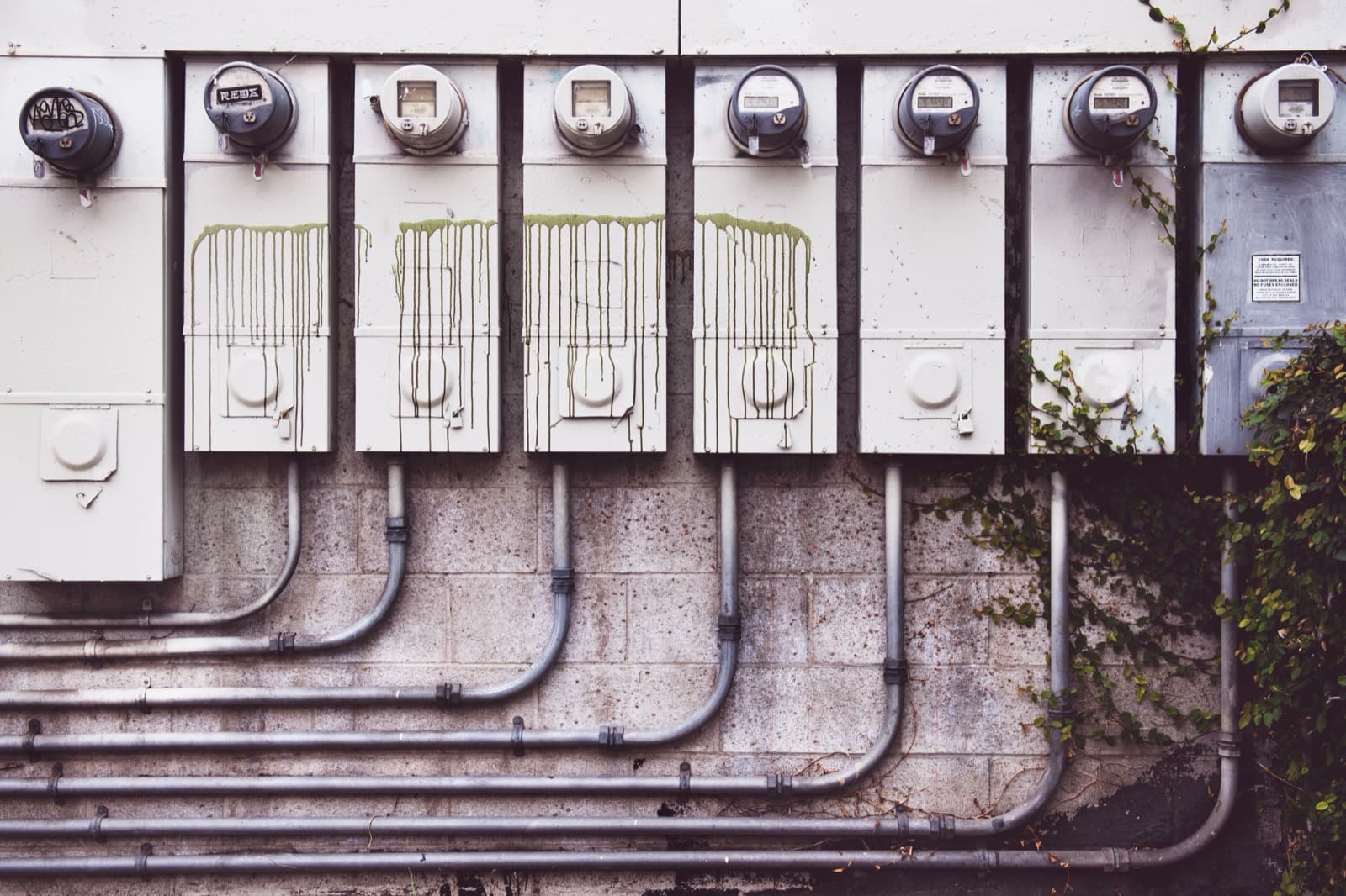 A row of residential electric meters on an exterior wall