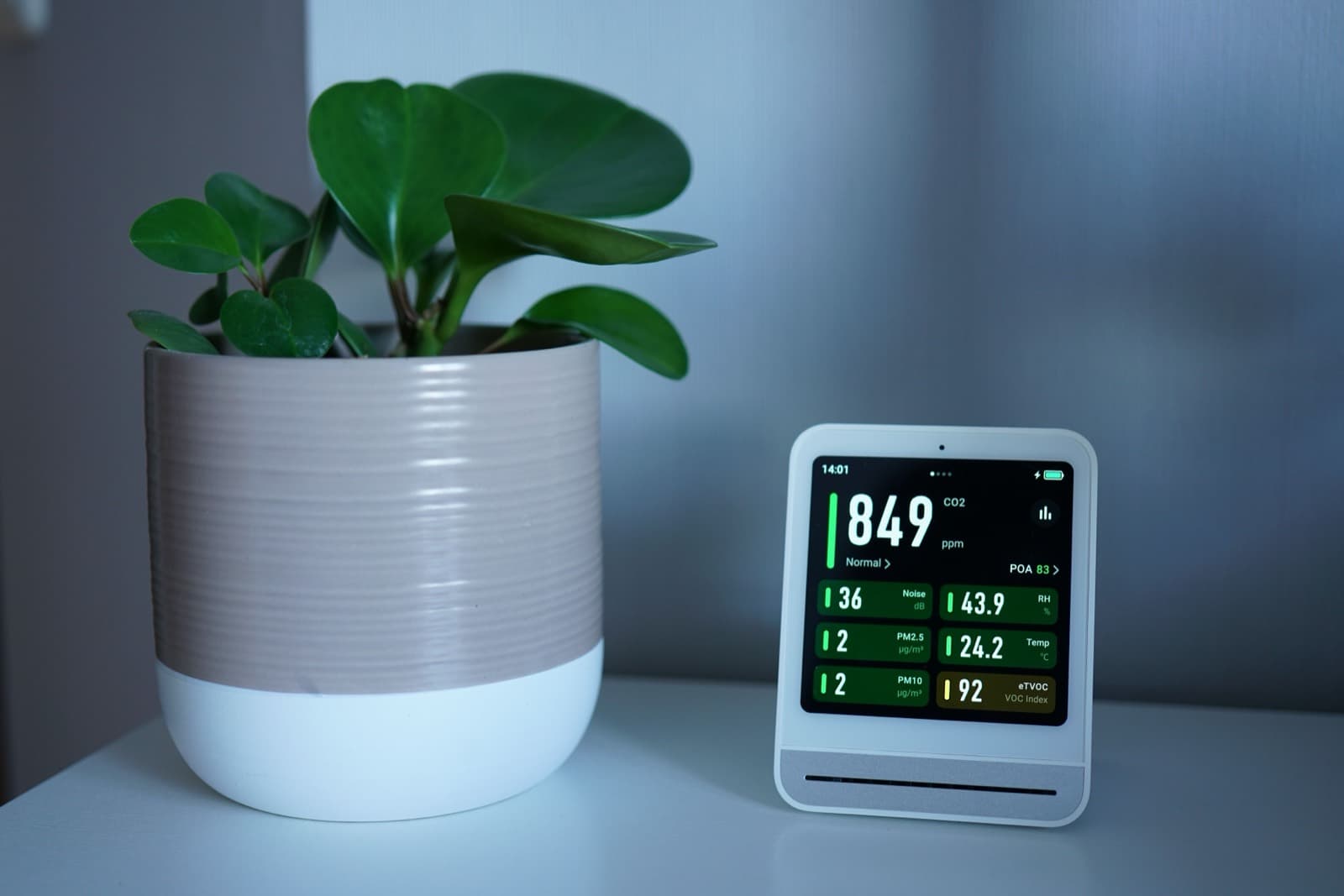 An indoor air quality monitor showing carbon dioxide and particulate readings