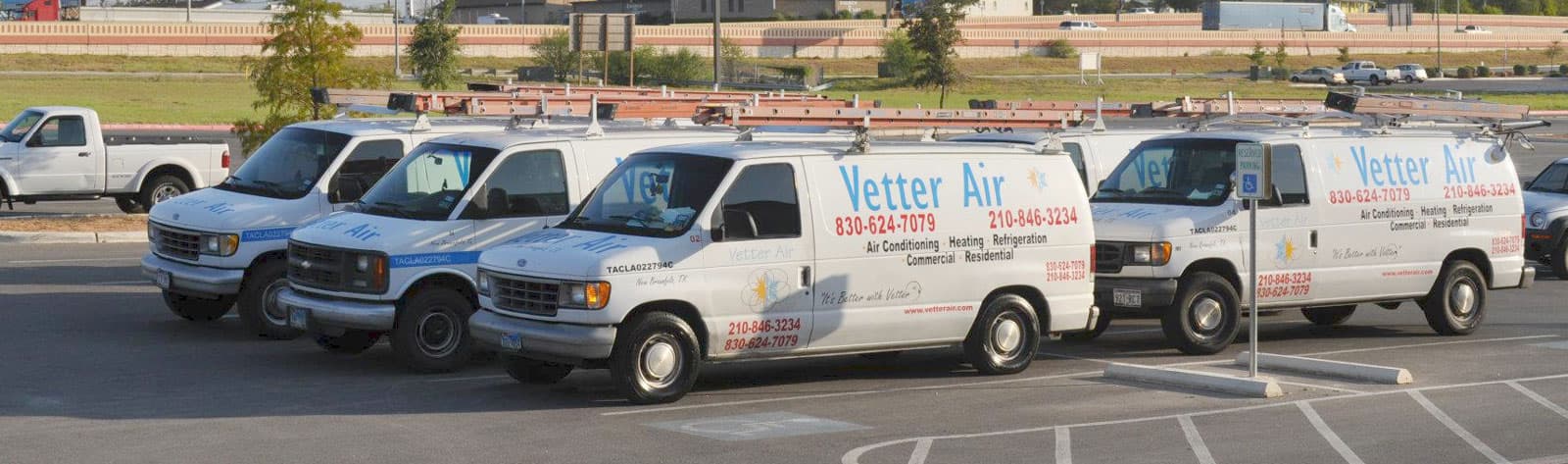 Row of Vetter Air air conditioning, heating and refrigeration service vans, marked commercial and residential