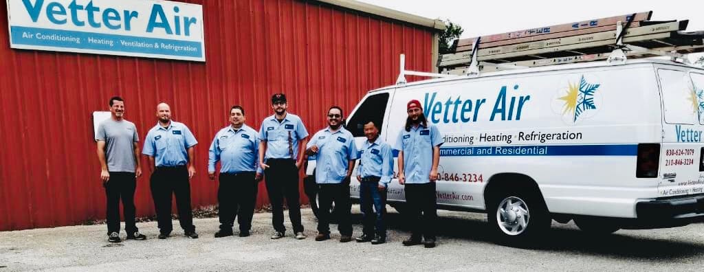 Vetter Air's New Braunfels HVAC team in uniform outside the Vetter Air shop, beside a company service van